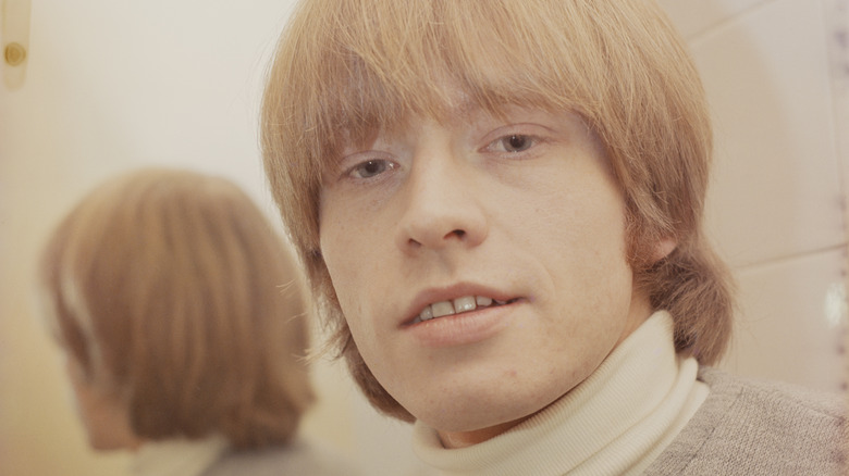 Brian Jones bowl hair cut in front of a mirror