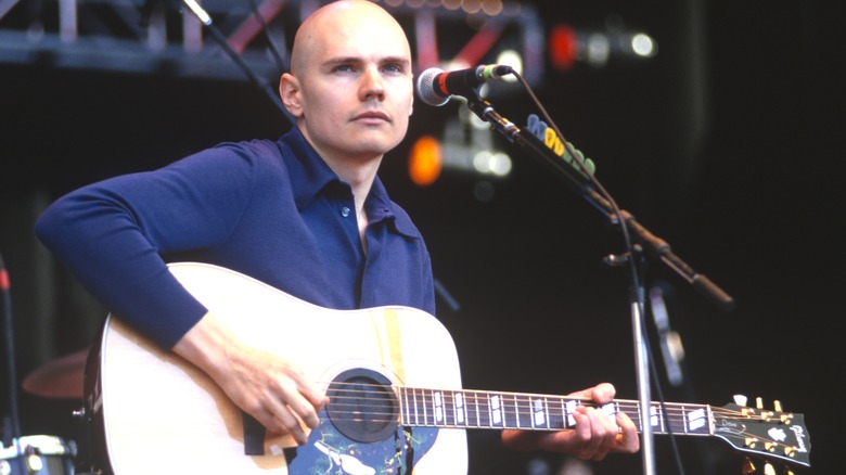 Billy Corgan plays guitar at microphone stand