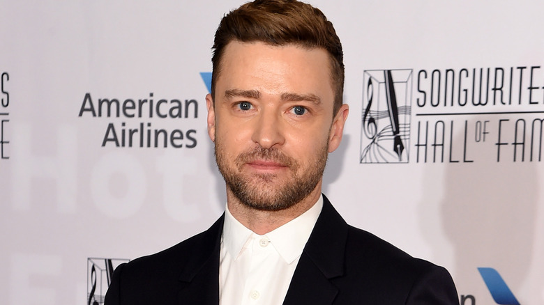 Justin Timberlake posing in white shirt black jacket