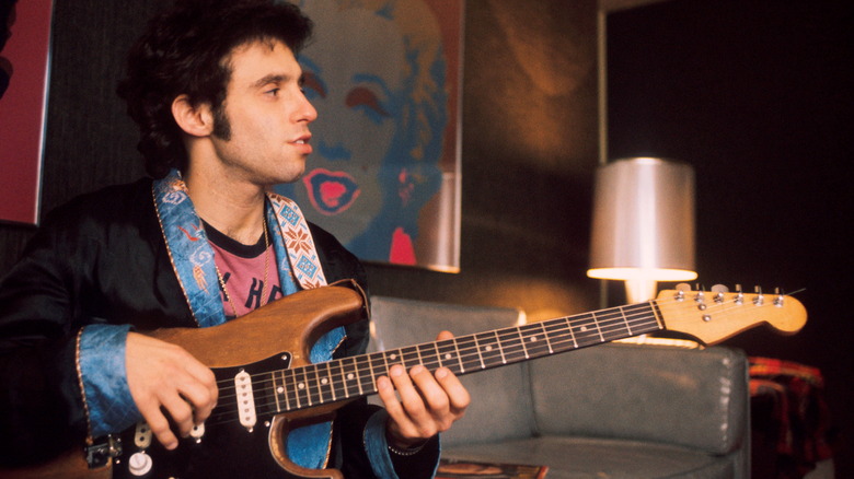 Nils Lofgren posing with guitar for photo