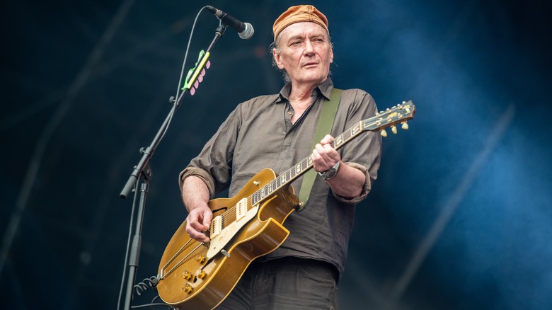 Geordie Walker playing guitar onstage