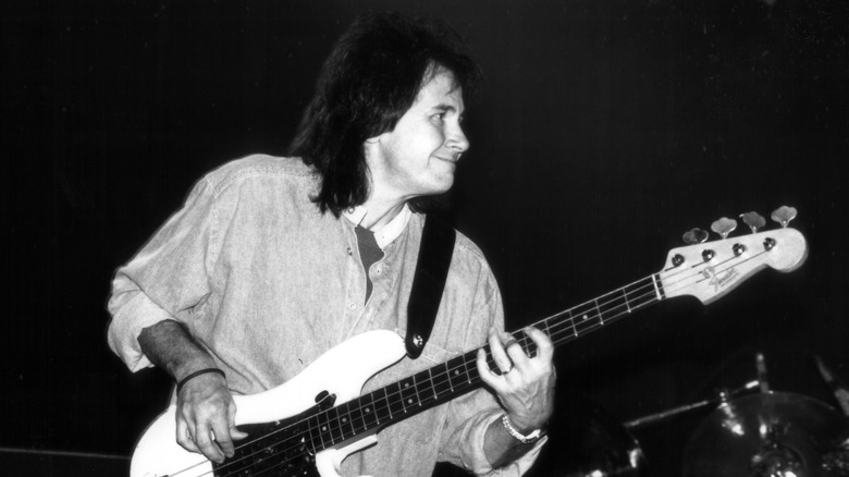 John Regan smiling while playing bass onstage