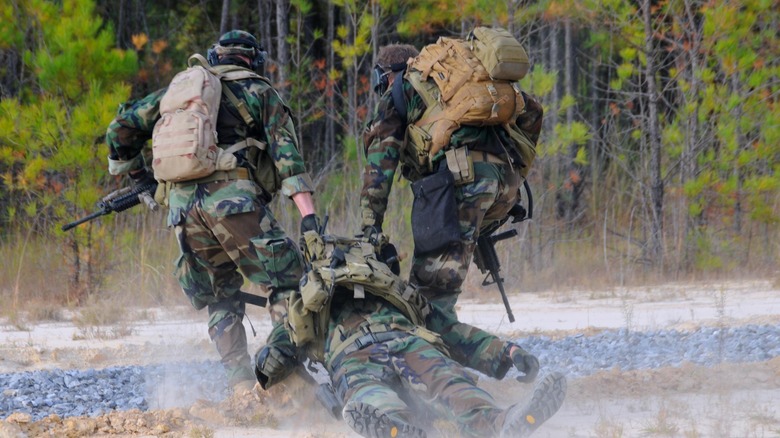 Soldiers carry an injured comrade