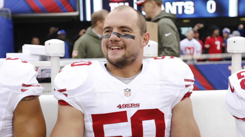 Chris Borland smiling on sidelines white 49ers jersey