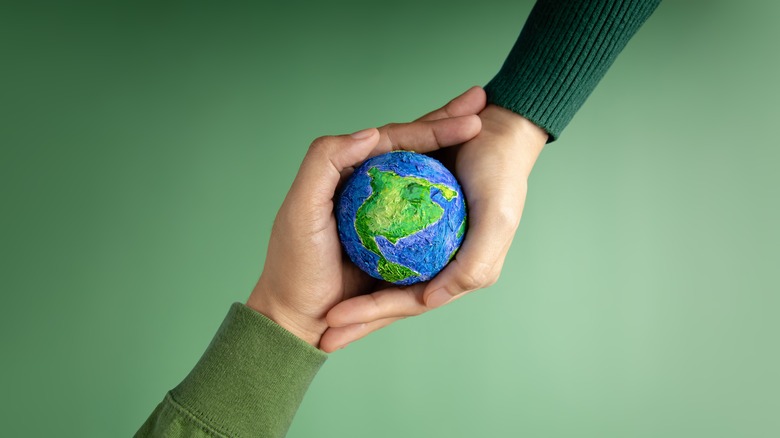 People holding paper mache Earth