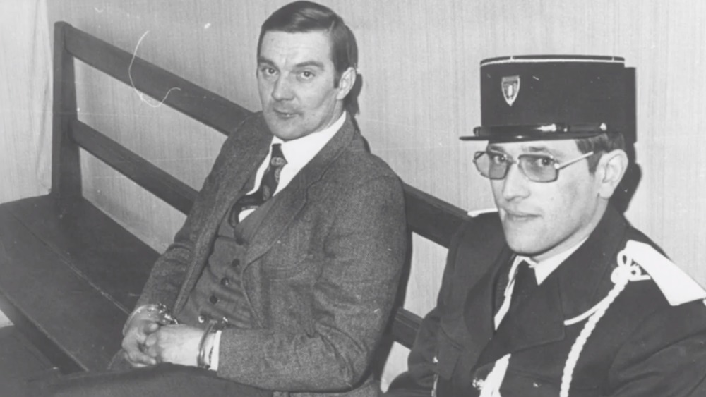Jérôme Carrein in handcuffs with policeman 