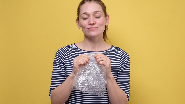 woman breaking bubble wrap