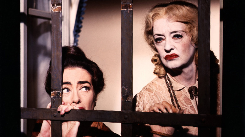 Joan Crawford and Bette Davis looking out of window