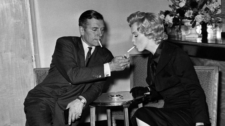 Laurence Olivier lighting a cigarette for Marilyn Monroe 