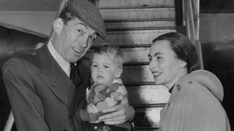 John Houston and Enrica Soma holding their son in front of a plane