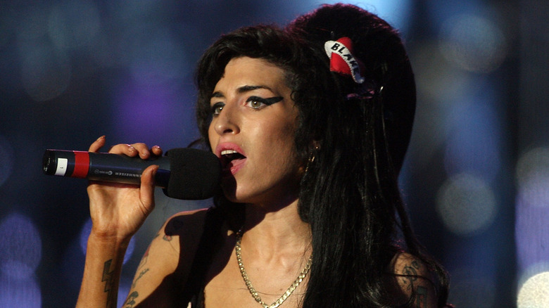 amy winehouse staring off while singing on stage in 2008