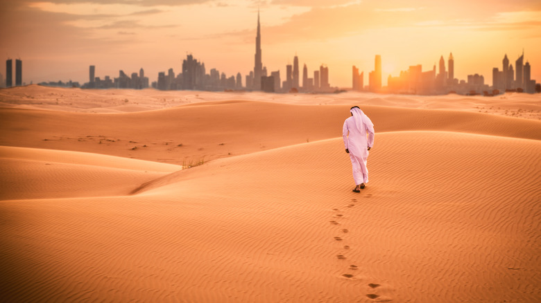 man walks through desert 