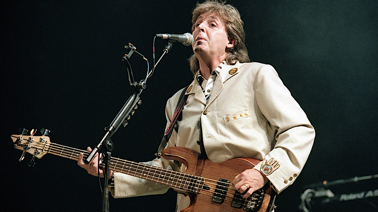 Paul McCartney playing guitar on stage