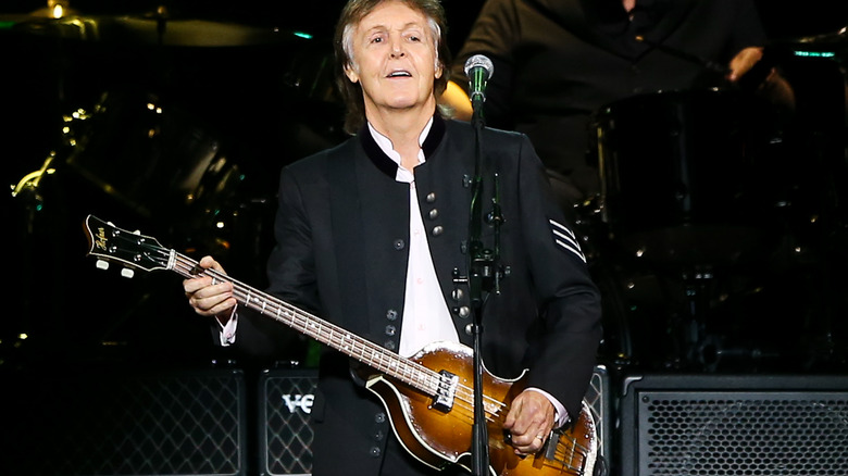 Paul McCartney playing guitar on stage