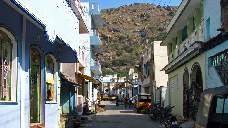 Attractive street in Vellore, Tamil Nadu, with pedestrians and tuk-tuks.