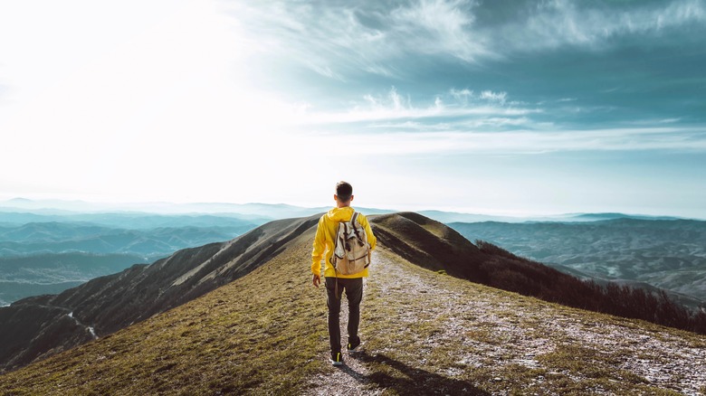 Lone backpacker walking mountain ridge