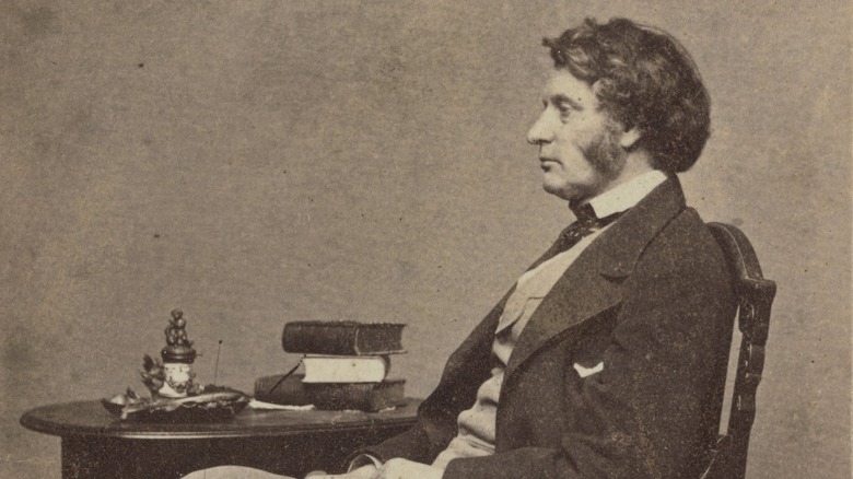 Charles Sumner seated by table