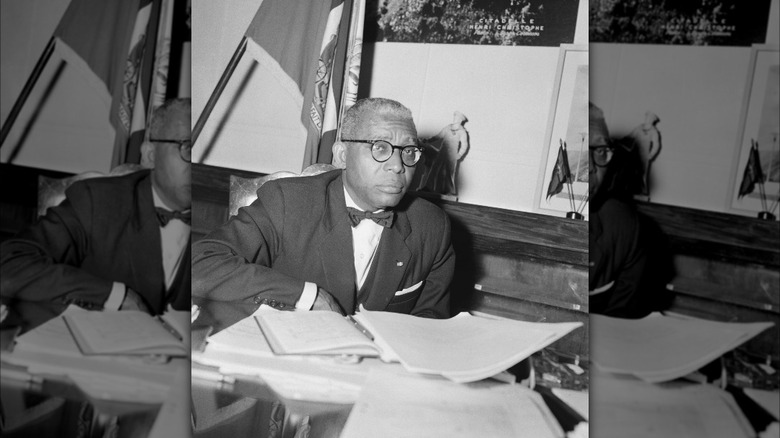 Francois Duvalier in bow tie sitting at desk