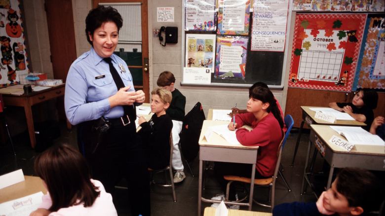 Police officer in classroom delivering D.A.R.E. drug talk