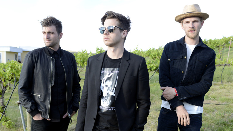 Foster the People posing in a field