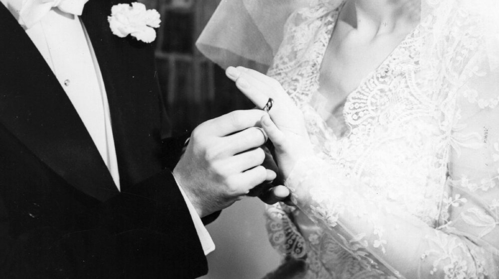 Bride and groom holding wedding rings