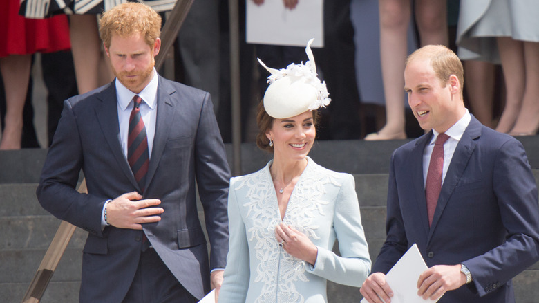 Princes William and Harry standing with Kate Middleton 