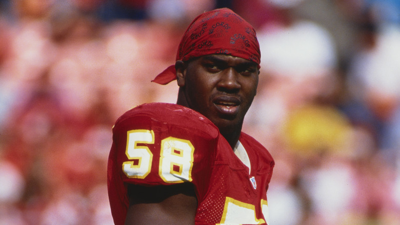 Derrick Thomas in a Chiefs jersey and baseball cap