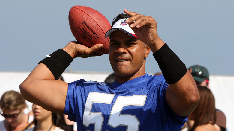 Junior Seau in a jersey and visor readying to throw a football