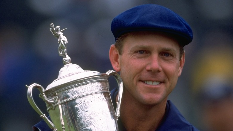 Payne Stewart smiling holding a trophy