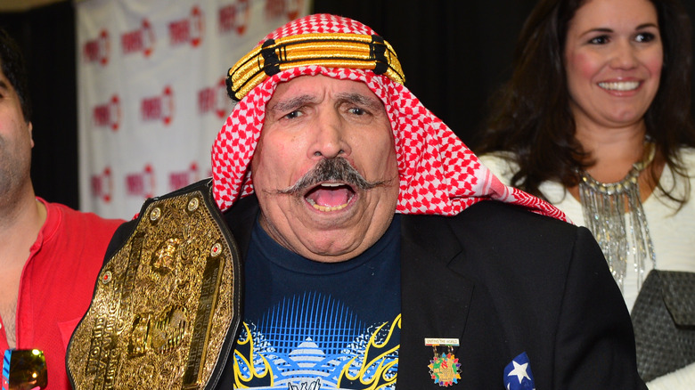 Iron Sheik holding championship belt