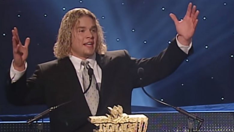 Matt Cappotelli black suit arms raised speaking event