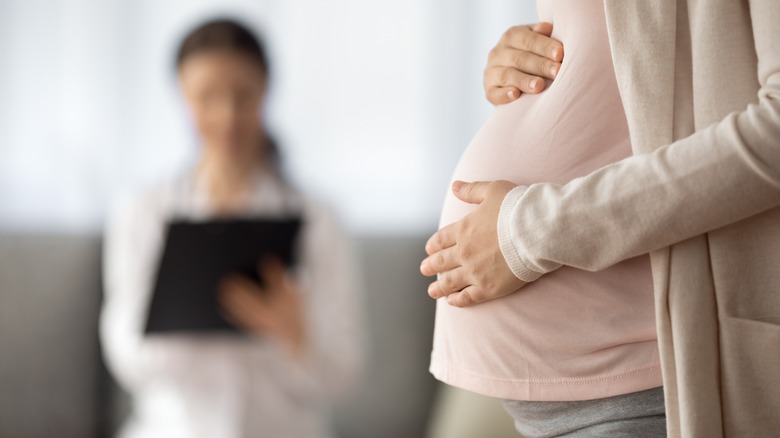 pregnant woman doctor holding clipboard