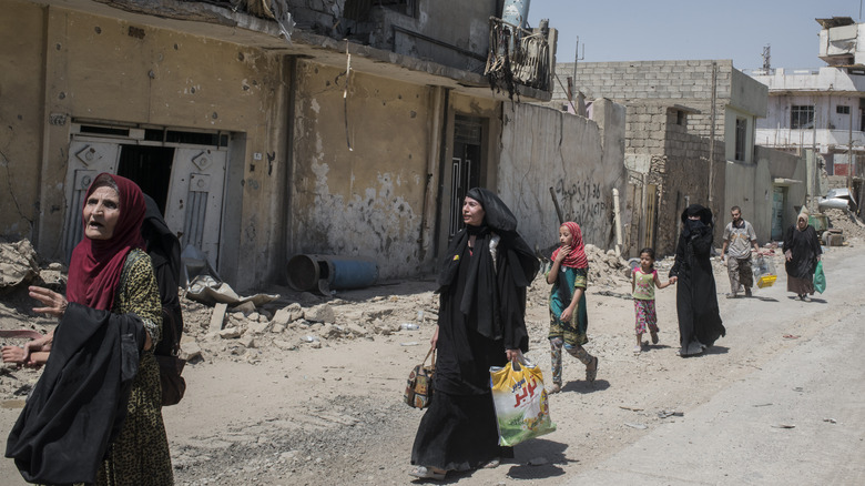 Iraqi civilians in a ruined city