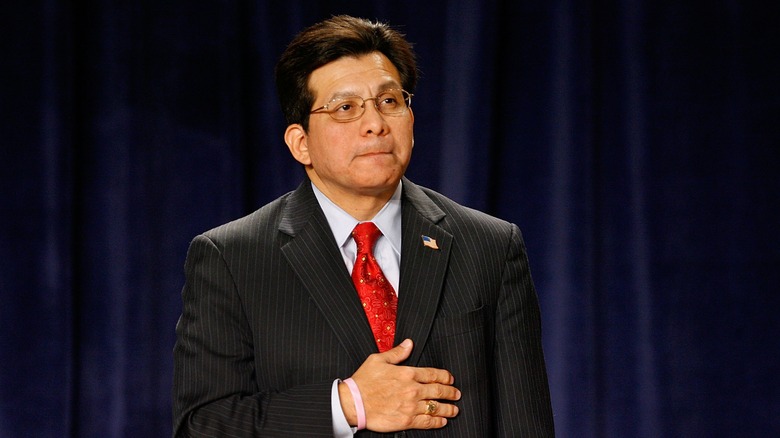 former attorney general Alberto Gonzales in suit hand on stomach