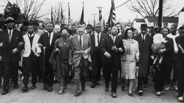 Martin luther king jr with crowd selma march american flags