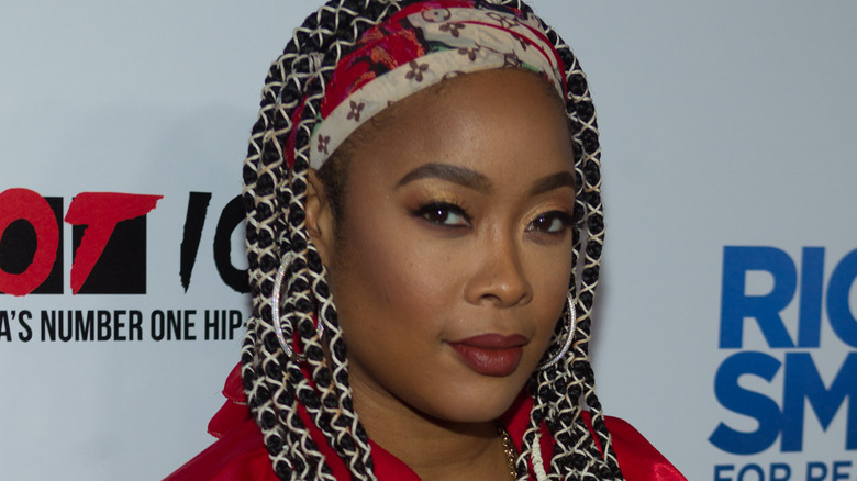 Da Brat with braids smiling at camera