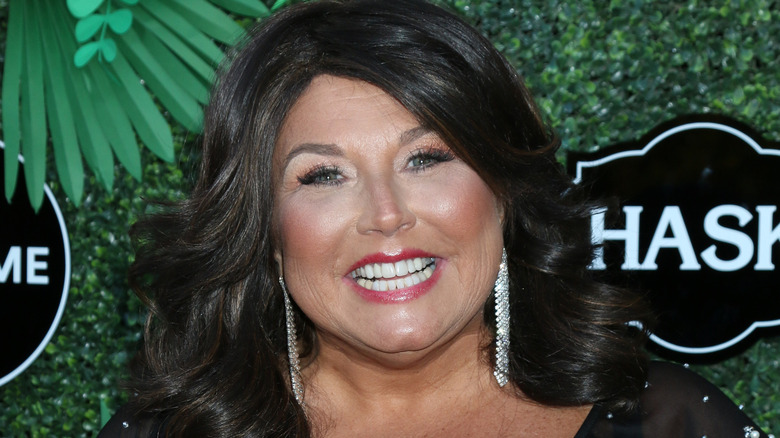 Abby Lee Miller smiling earrings at event