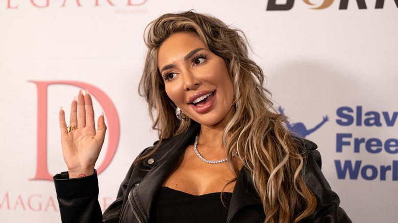 Farrah Abraham smiling waving black jacket at event