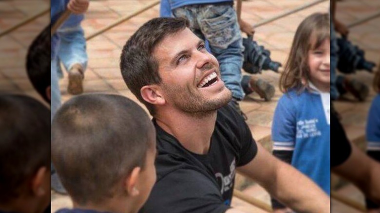 Eric Hill smiling looking up with children