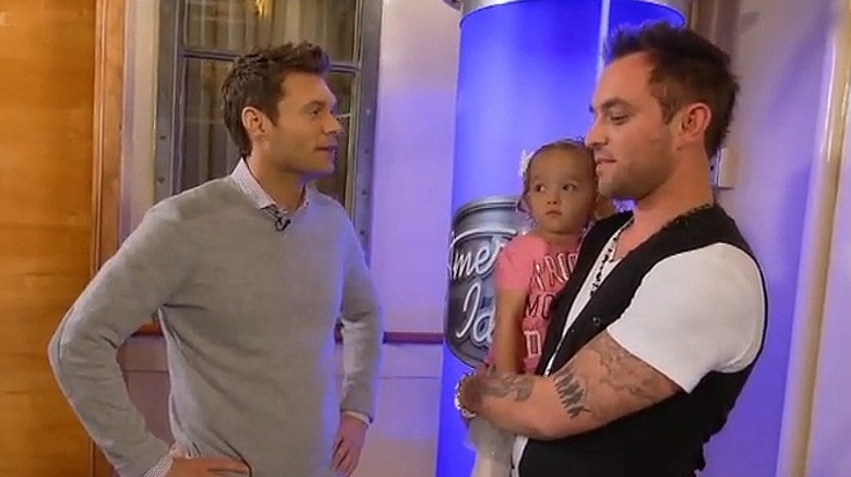 Matt Farmer talks to Ryan Seacrest while holding daughter