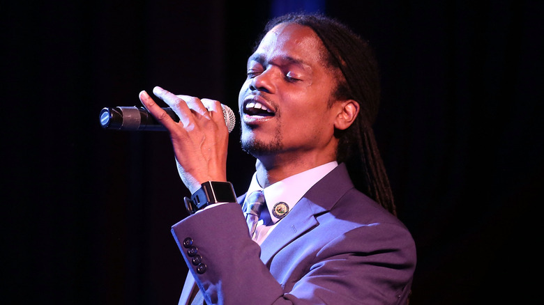 Landau Eugene Murphy Jr. sings into microphone with eyes closed