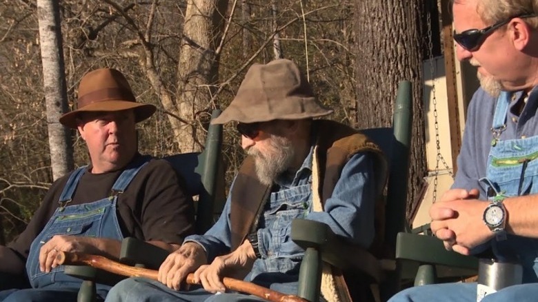 Members of cast sitting in woods