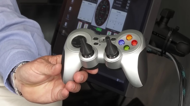 A hand holding the game controller used to pilot the Titan