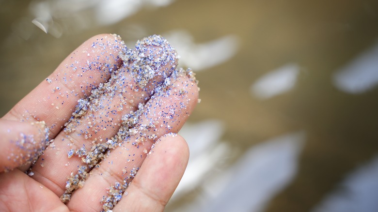 Microplastics coating a human hand