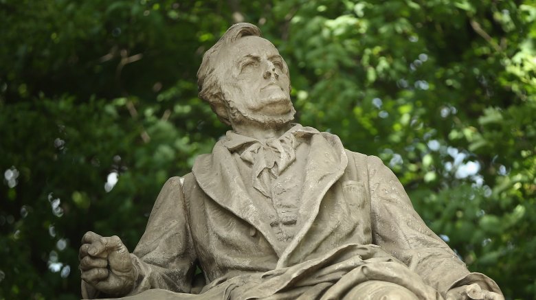 Statue of Richard Wagner sat looking up trees