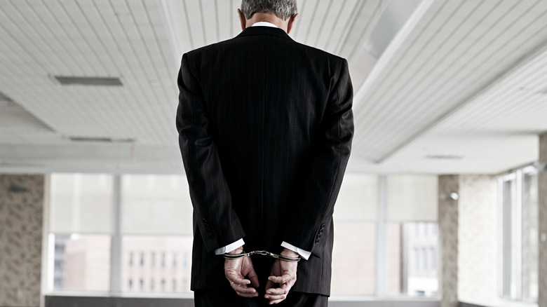 man in suit handcuffed