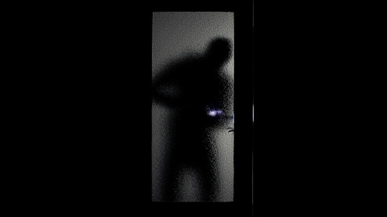 Silhouette of burglar through a glass door