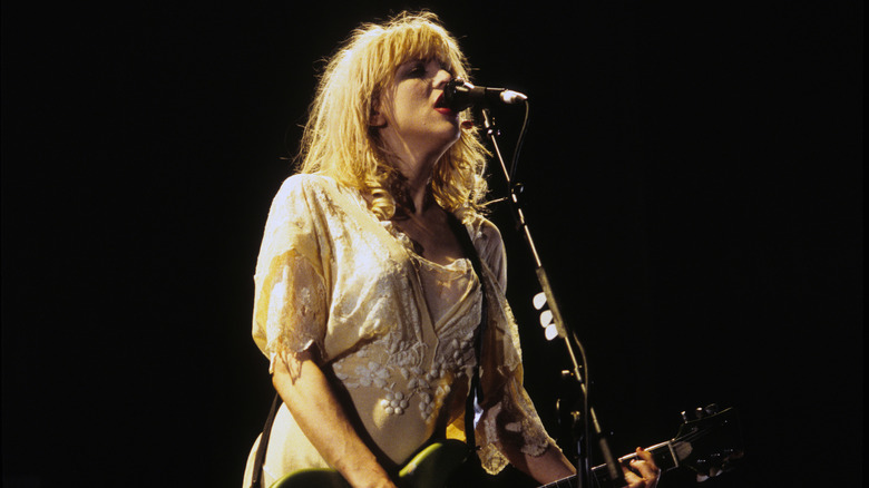 Hole's Courtney Love singing and playing guitar on stage at the Roy Wilkins Auditorium in 1994