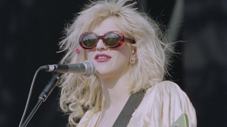 Courtney Love wearing sunglasses and singing on stage at the 1994 Reading Festival