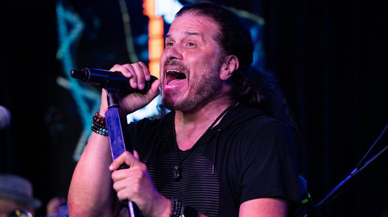 Jeff Scott Soto holding the microphone and singing on stage